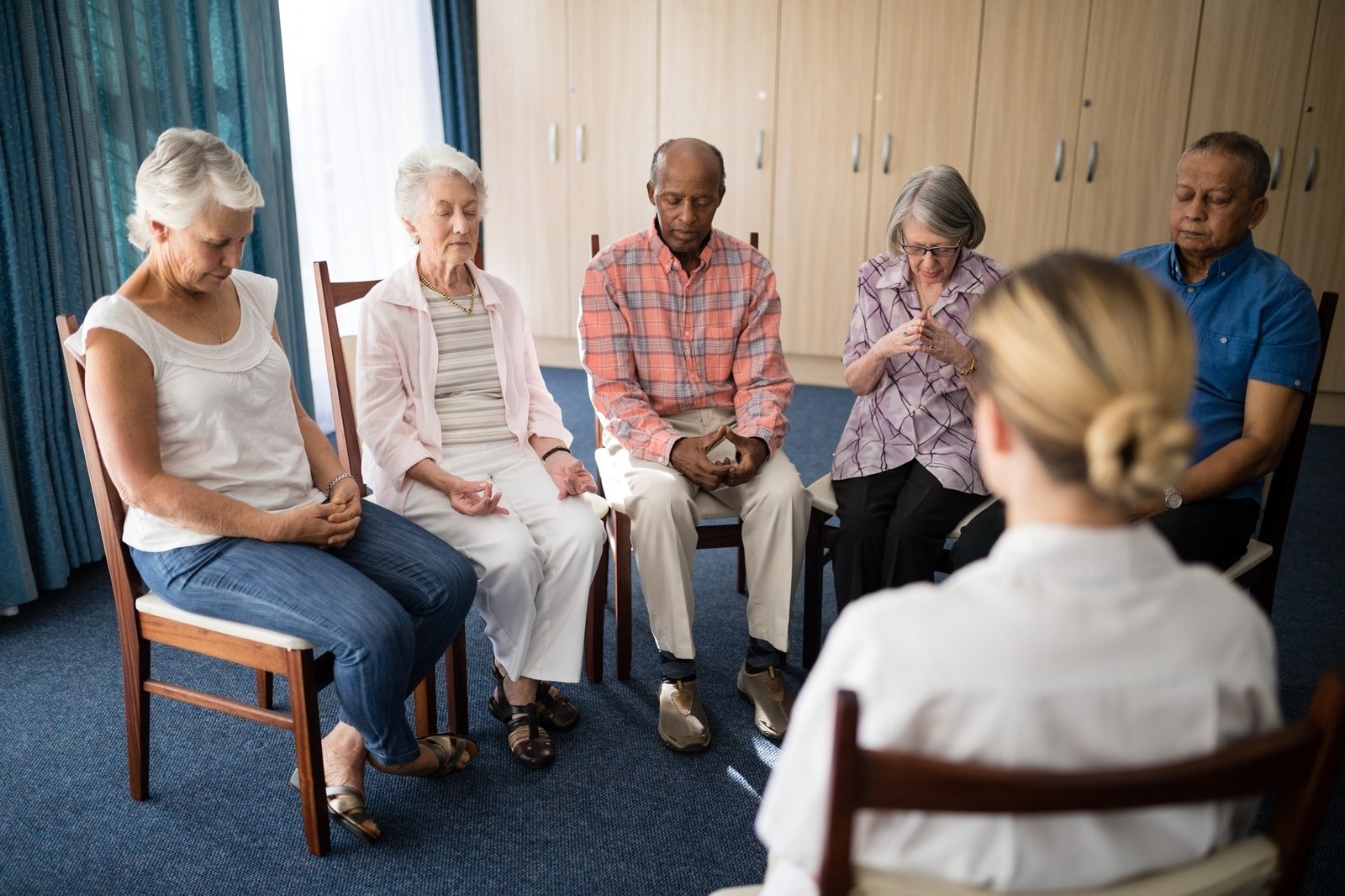 Senior people meditating with female doctor
